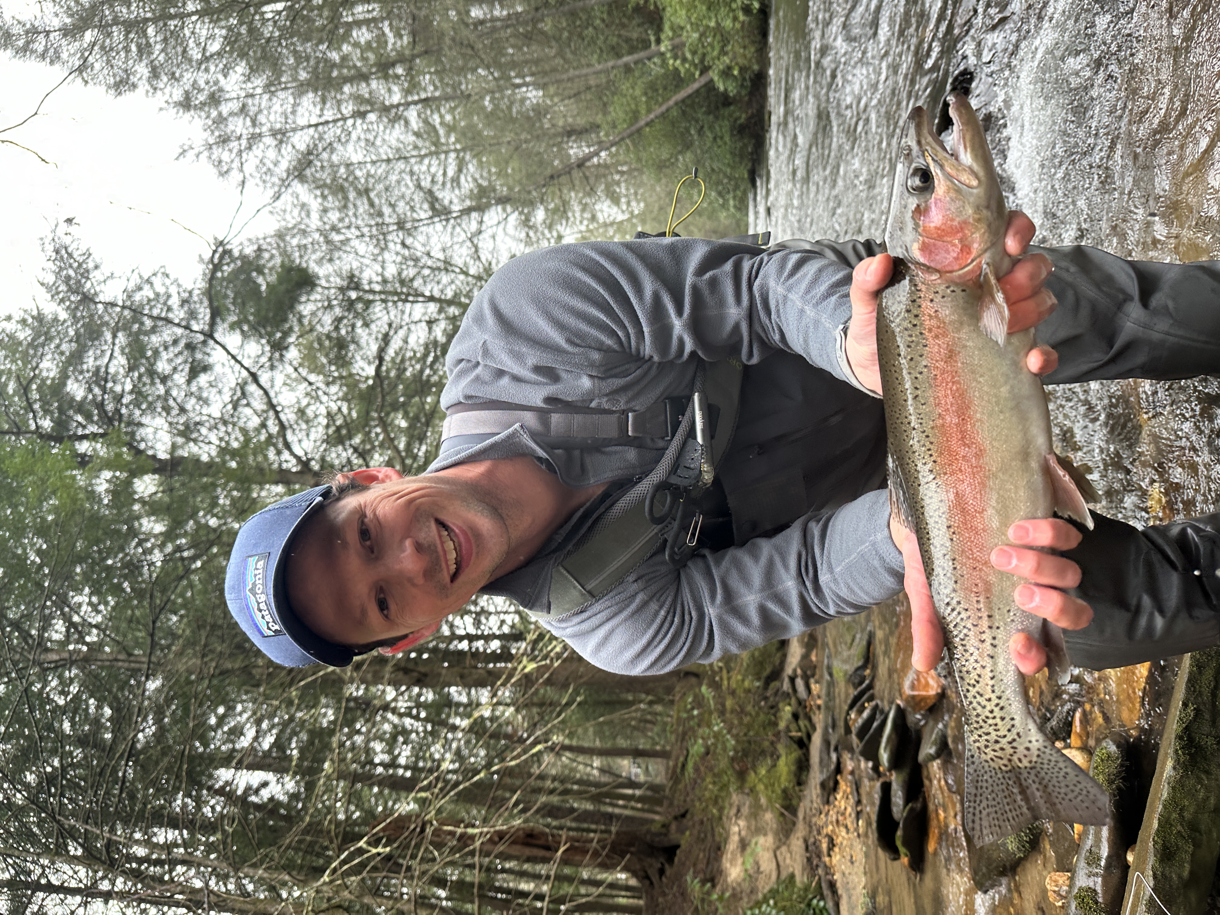 An angler holding a large trout on the river